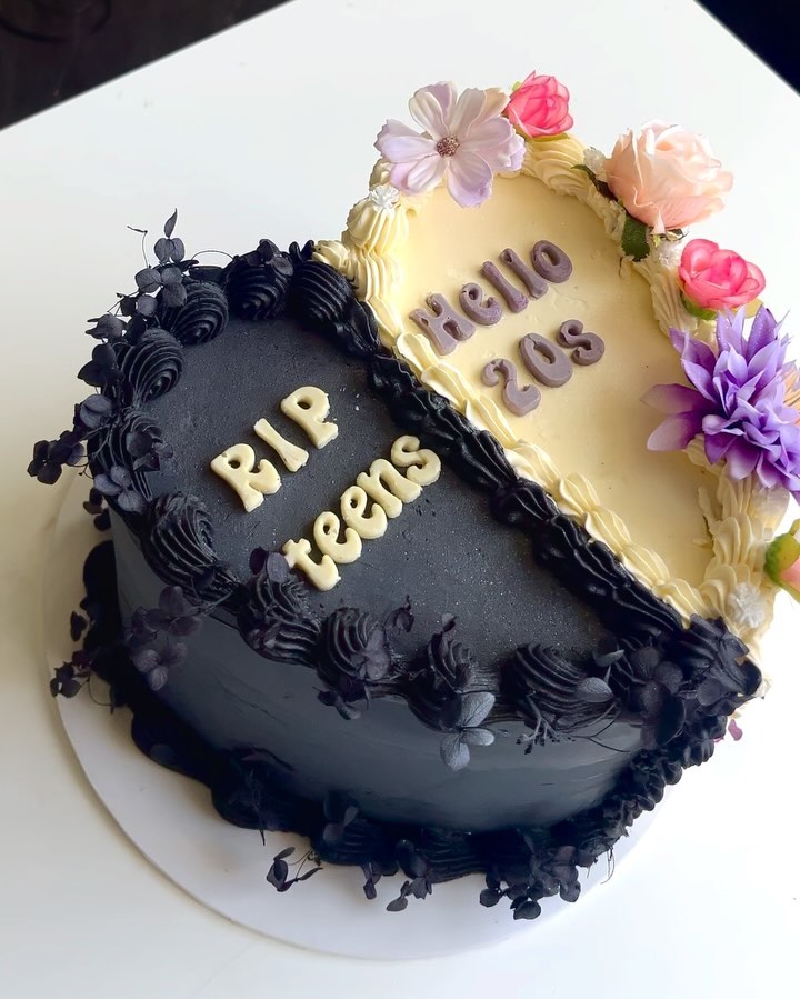 Half black, half cream 50/50 heart cake reading 'RIP teens, Hello 20s'