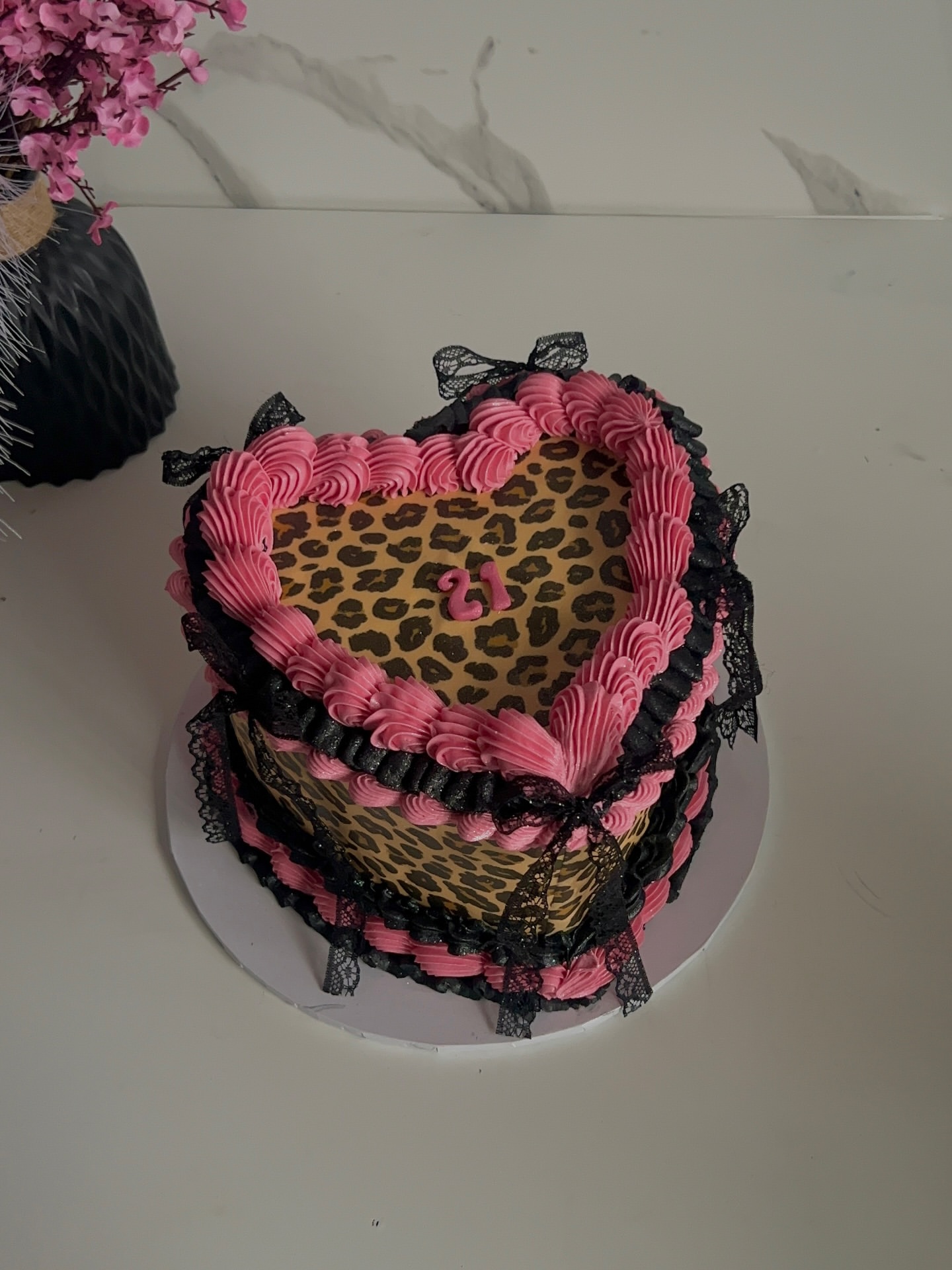 Two-tier leopard print heart cake with pink piping and black lace bows by The Cake Realm